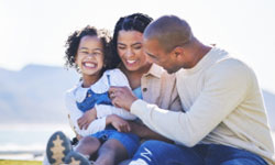 A couple and their young daughter enjoying time together outdoors near a lake with mountains in the distance, they feel confident that their whole life insurance will protect their family’s financial security. A couple and their young daughter enjoying time together outdoors near a lake with mountains in the distance, they feel confident that their whole life insurance will protect their family’s financial security.