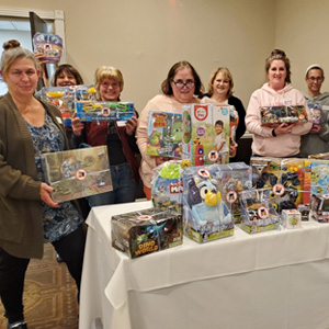 Women standing in front of table with board game displayed